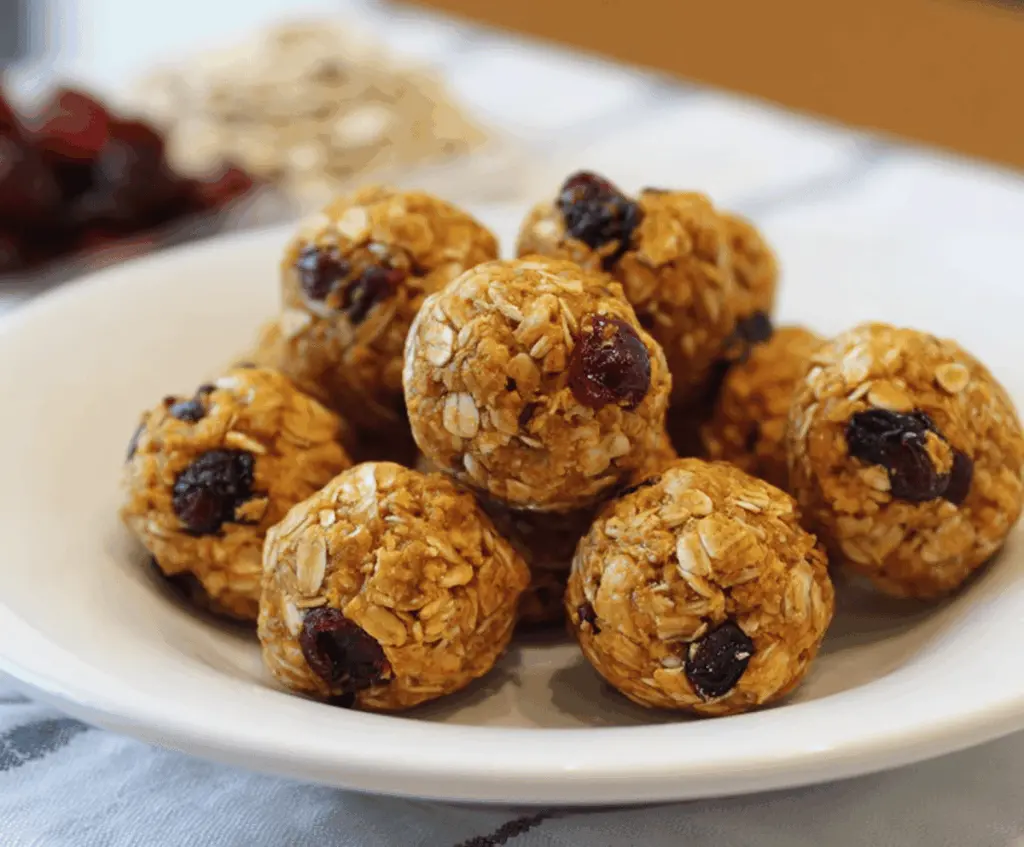 Healthy Pumpkin Cranberry Energy Bites with oats, nuts, and seeds on a white plate, perfect for a nutritious snack