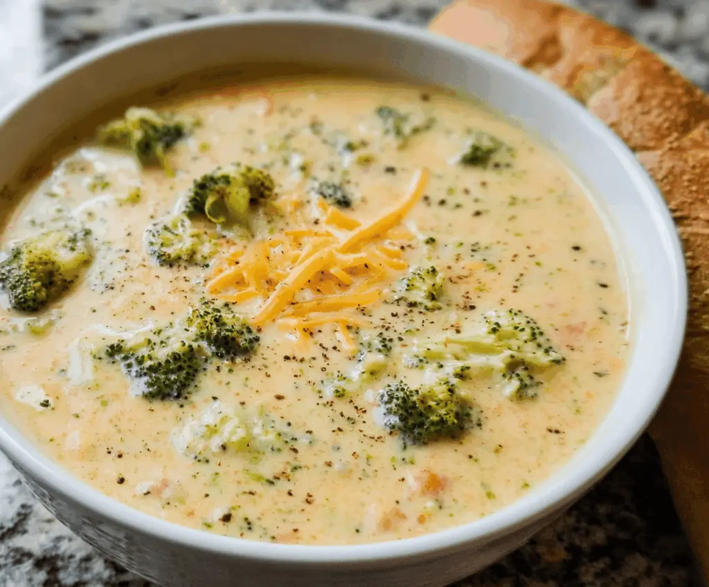 Creamy broccoli cheese soup in a bowl garnished with fresh herbs and melted cheese, perfect for a comforting meal.