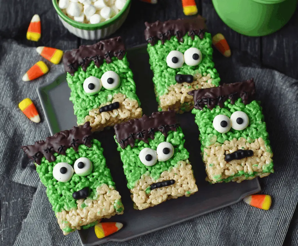 Colorful Frankenstein Rice Krispie Treats decorated with green icing, googly eyes, and spooky candy accessories for Halloween fun