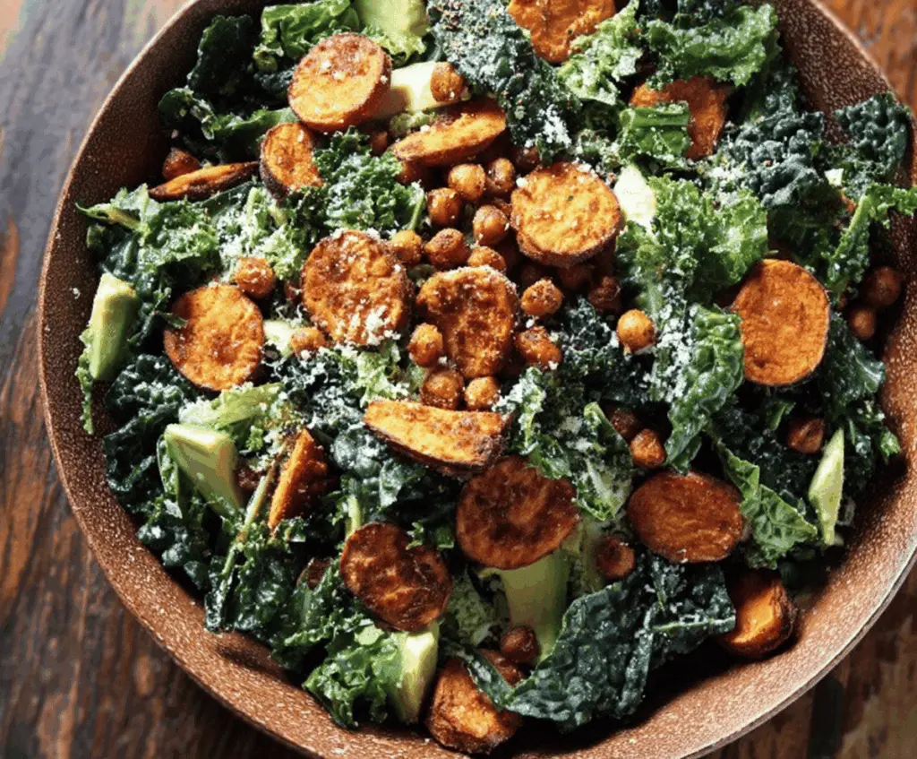 Fresh sweet potato, kale, and croutons in a Caesar salad bowl, featuring vibrant greens, roasted sweet potatoes, and creamy Caesar dressing, perfect for a healthy and flavorful meal.