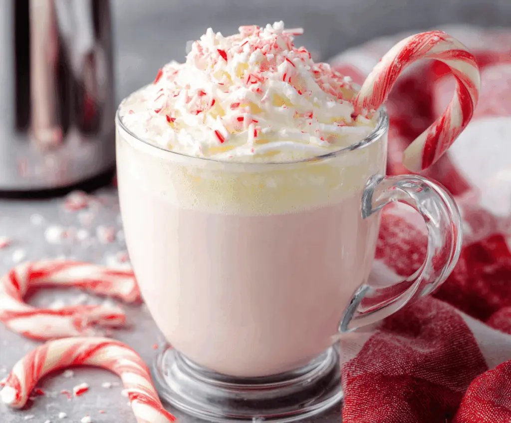 Creamy Crockpot Candy Cane White Hot Chocolate served in a mug with a candy cane garnish