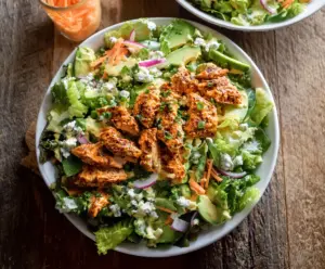 Creamy Buffalo Ranch Chicken Salad served with fresh vegetables and herbs.