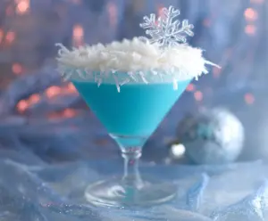 Festive Christmas Snowflake Cocktail with icy blue decoration and holiday-themed glass.