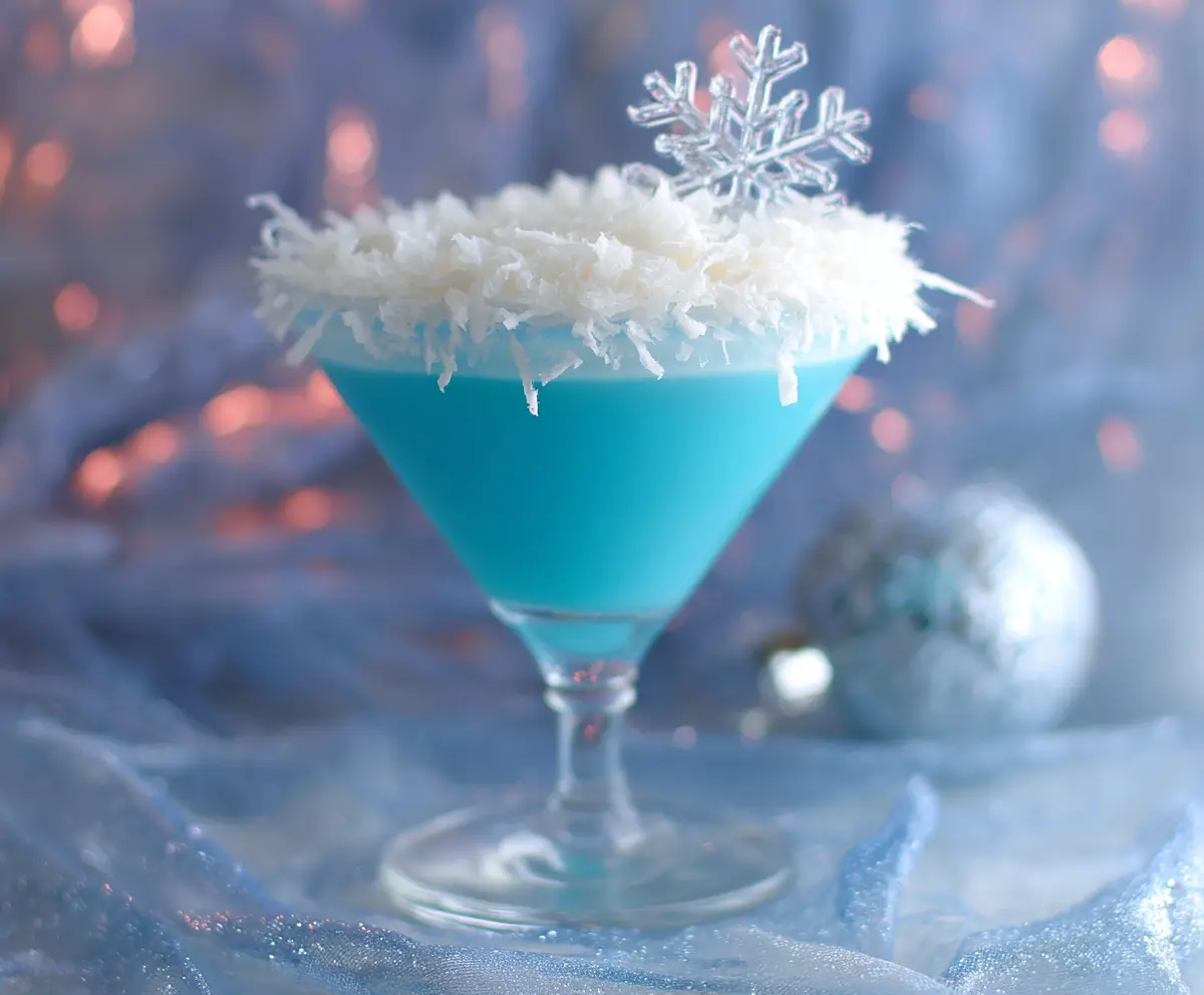 Festive Christmas Snowflake Cocktail with icy blue decoration and holiday-themed glass.
