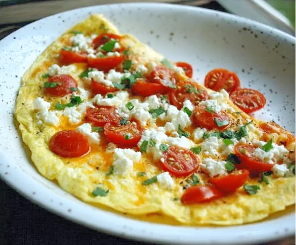 Delicious feta and tomato omelet served on a plate, perfect for breakfast or brunch.