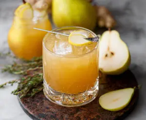 Ginger Pear Bourbon Cocktail in a glass with pear slices and ginger slices, served chilled.