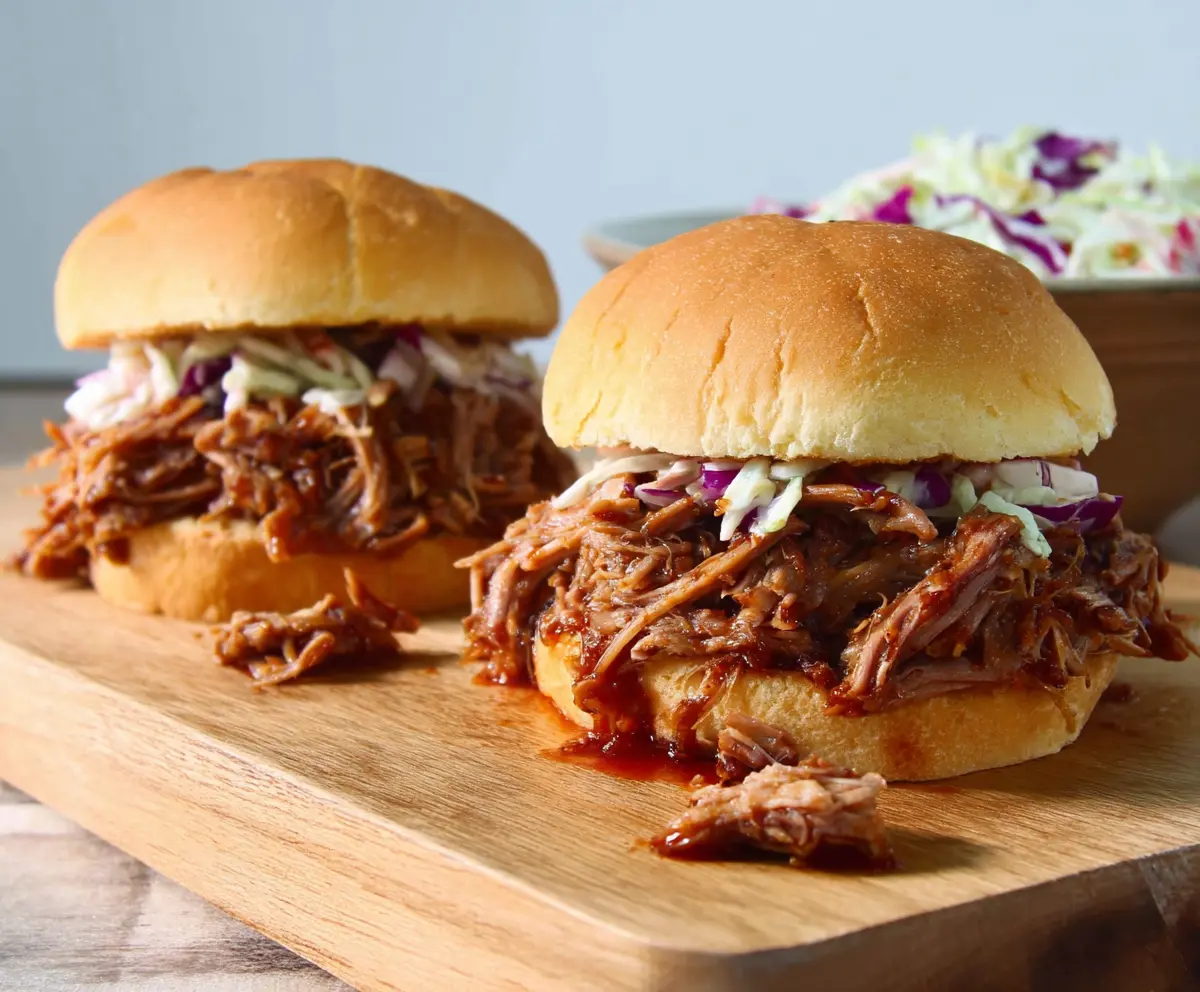 Delicious pulled pork sandwiches topped with coleslaw served on a bun, perfect for a barbecue meal.