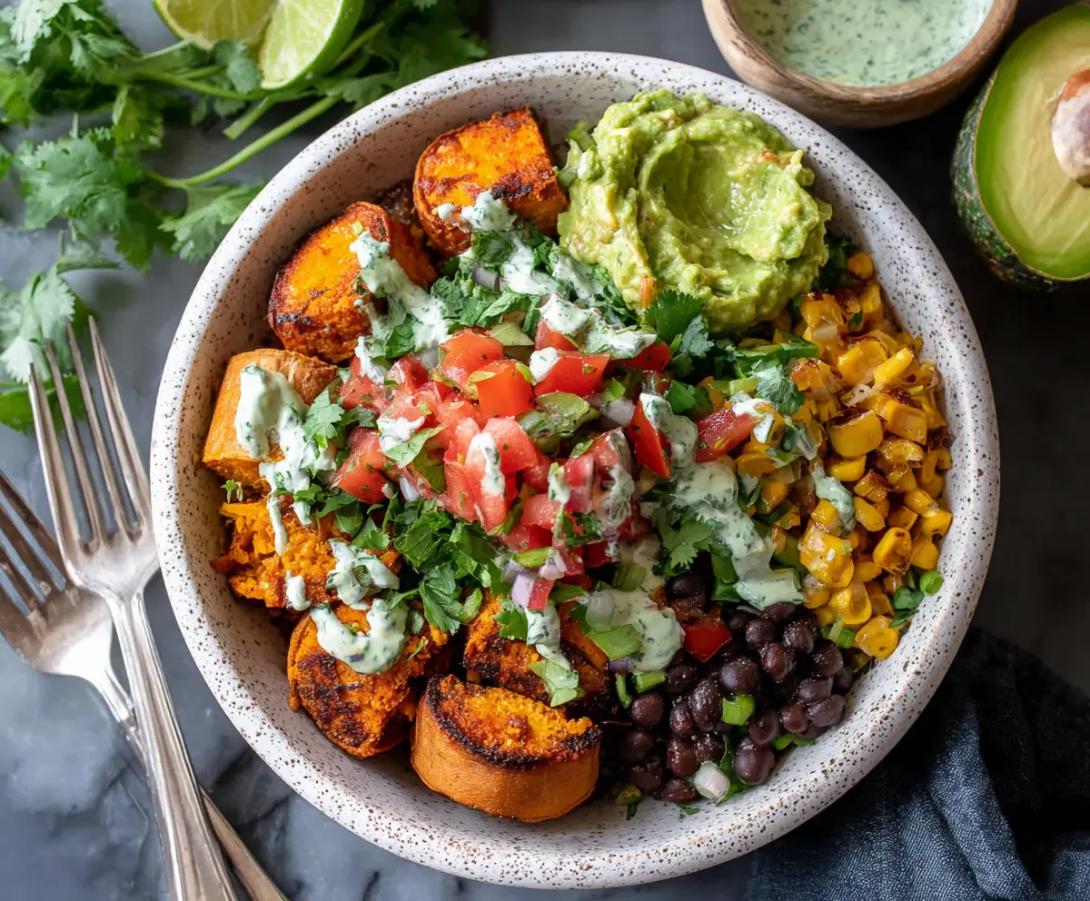 Colorful sweet potato taco bowls with fresh vegetables and creamy sauce ready to serve.