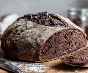 Golden-brown Double Chocolate Sourdough Bread with rich chocolate streaks in a rustic setting.