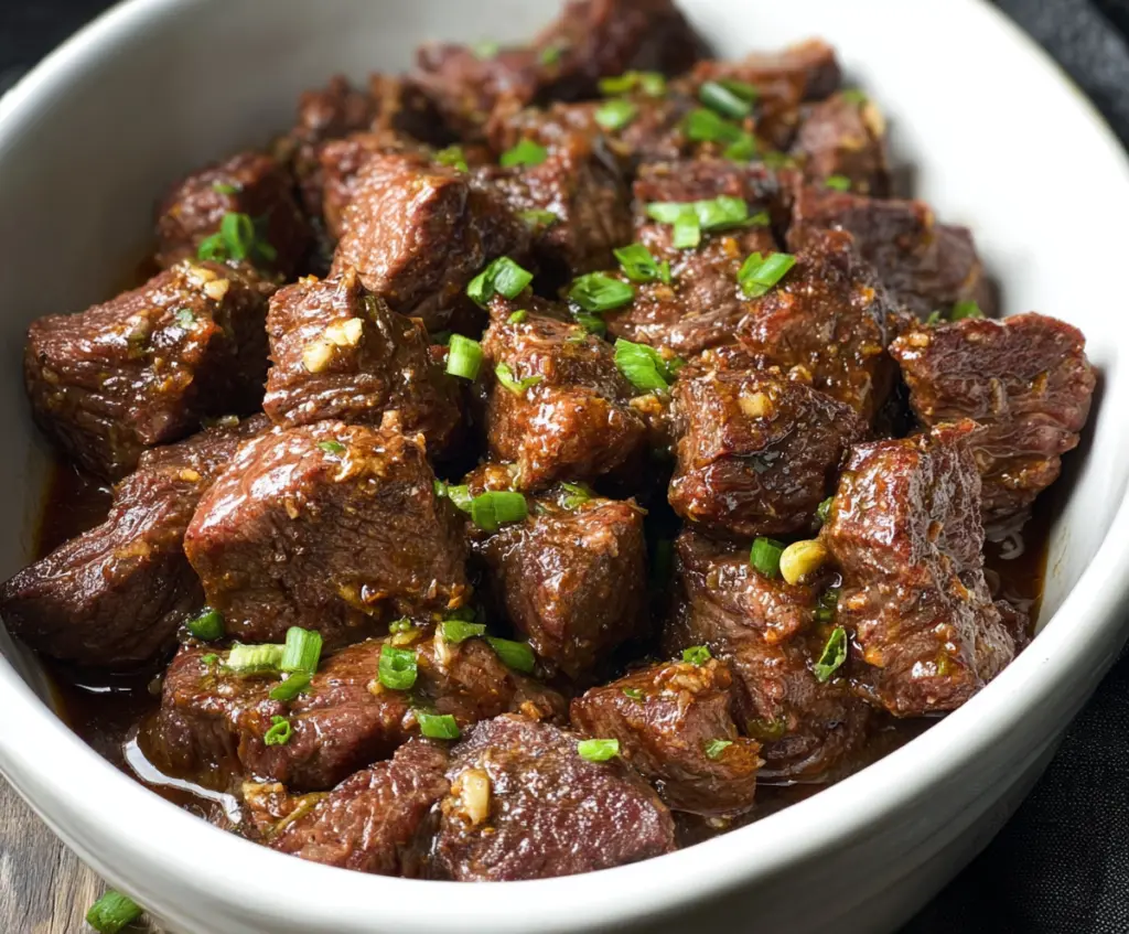 Delicious high protein garlic butter beef bites cooked in a slow cooker, perfect for a nutritious meal.
