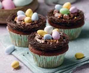 Decorative Easter Egg Nest Cupcakes with colorful candy eggs and green frosting grass.