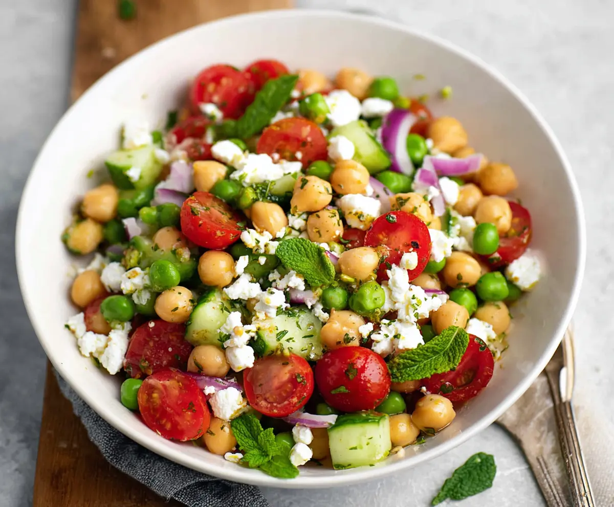 Fresh Mediterranean Pea Salad with cherry tomatoes, feta cheese, and herbs in a bowl