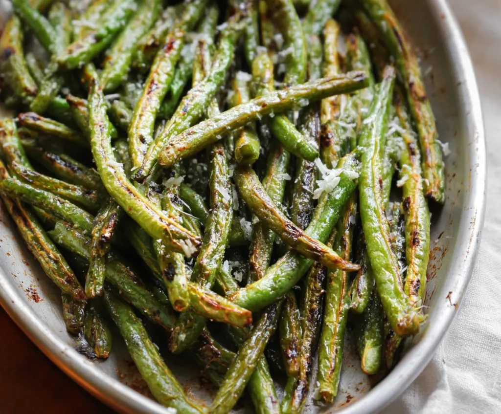 Delicious roasted green beans seasoned with herbs on a baking sheet