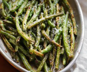 Delicious roasted green beans seasoned with herbs on a baking sheet