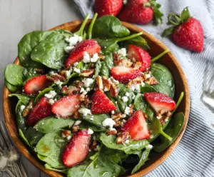 Fresh spinach and ripe strawberries in a vibrant spinach strawberry salad.