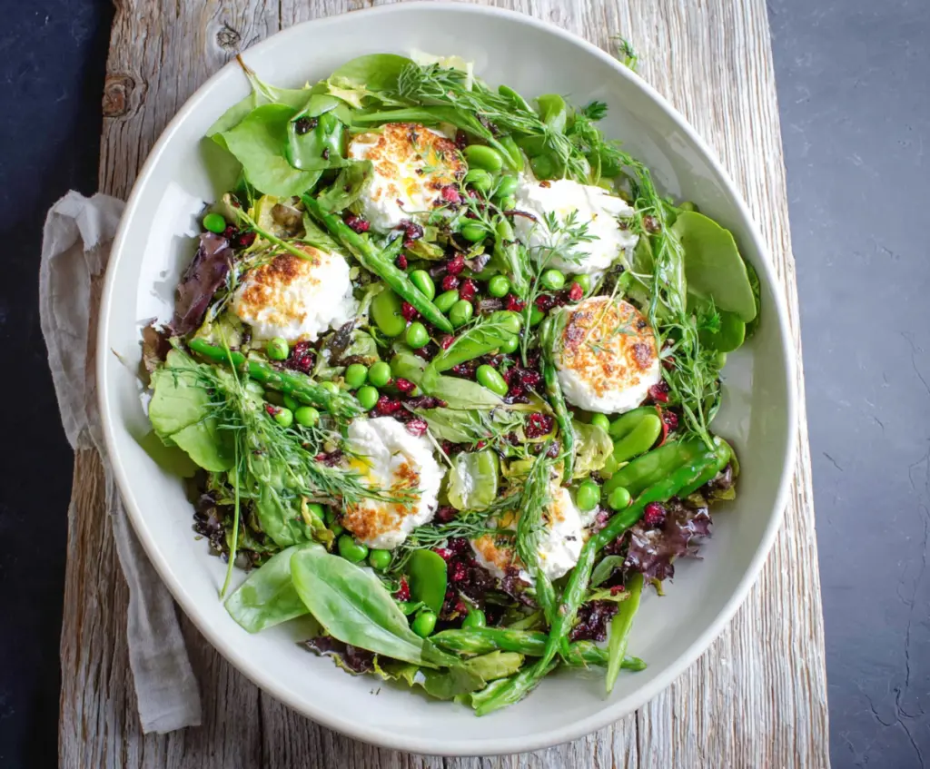 Fresh spring salad with goat cheese, mixed greens, and colorful vegetables for a healthy meal.